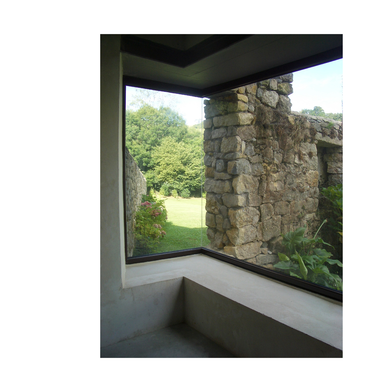 Corner window looking out to ruins and garden — rural Spain